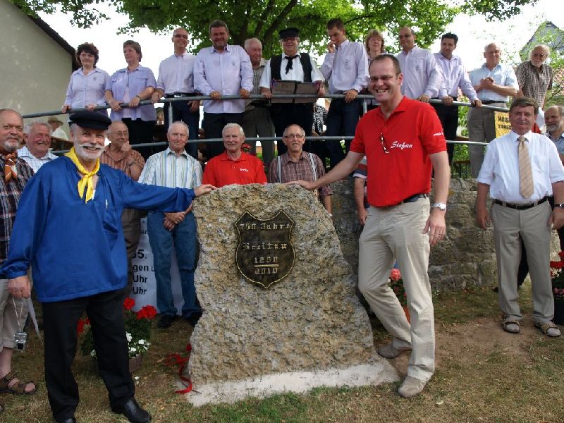 Landrat Stefan Reuss (r.) enthüllt zusammen mit Richard Kröll (l.) den Gedenkstein zur 750 Jahr-Feier